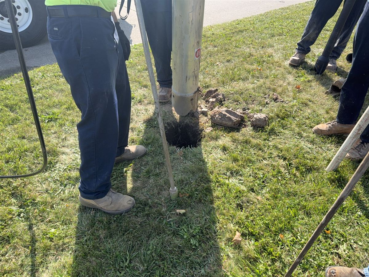 Auger drilling fence post holes on Michigan residential property