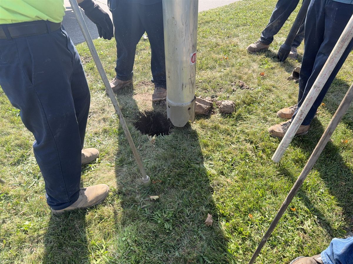 Fence post hole team setting posts on Michigan job site